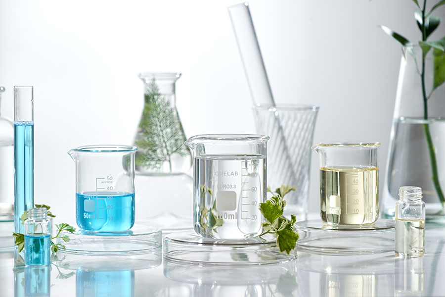 Skincare science research setup with lab glassware, clear and blue liquids, and botanical samples—symbolizing ingredient testing and evidence-based skincare journal research.